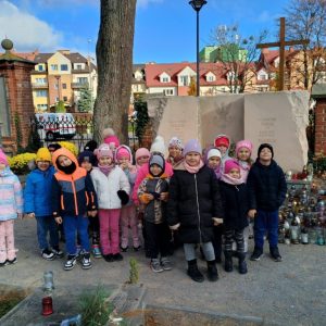 Dzieci uśmiechnięte stoją przy Grobie Nieznanego Żołnierza