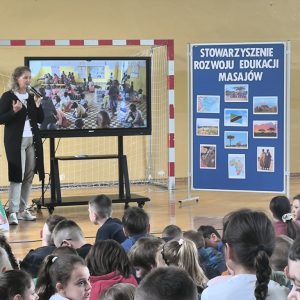 Przedstawicielka Stowarzyszenia Rozwoju Edukacji Masajów pokazująca prezentację multimedialną dla uczniów.