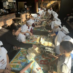 Uczniowie kl.2a siedzą w restauracji i własnoręcznie wykonują makaron w restauracji Franco.