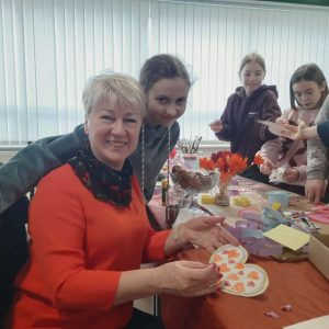 uczestnicy warsztatów pozują do zdjęcia i trzymają elementy kompozycji