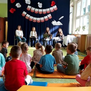 Przedszkolaki siedzą na dywanie i słuchają „Bajki o ziarnie”.