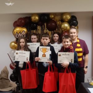 Drużyna z organizatorką konkursu, dyplomami i nagrodami.