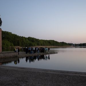 uczestnicy stoją pod pomnikiem „Niosącej”