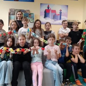 Grupa świetlicowa z wychowawcą, dzieci trzymają czytelniczy łańcuch.