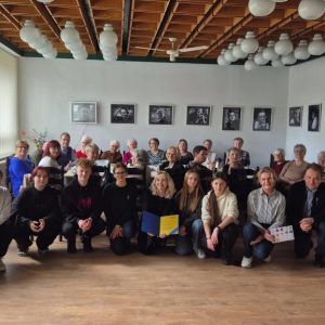 spotkanie wielkanocne z Klubem 50 PLUS: wolontariusze i seniorzy pozują do pamiątkowego zdjęcia