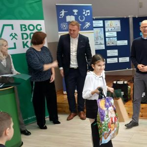 Zwyciężczyni pieszego miejsca trzyma torbę z nagrodami i dyplom.