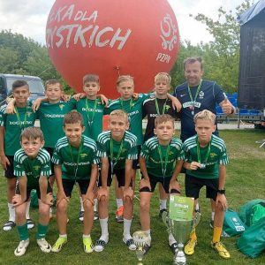 drużyna Szkoły Podstawowej nr 2 w Łęcznej wraz z trenerem na boisku piłki nożnej