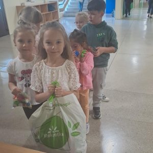 Dzieci trzymające worki z nakrętkami.