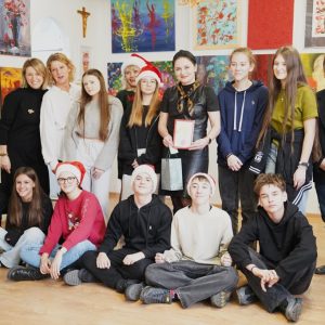 Dyrekcja i pracownicy Centrum Kultury w Łęcznej, wolontariusze z opiekunką pozują do zdjęcia.