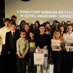 43 uczestników konkursu stoi na tle banneru konkursowego ze swoimi opiekunami