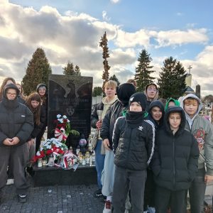 uczniowie stoją przy grobie powstańców styczniowych