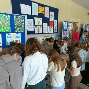 uczniowie rozwiązują zadania matematyczne, w tle matematyczne prace plastyczne