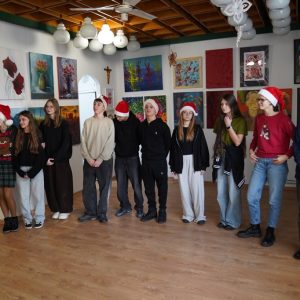 Wolontariusze z opiekunką w trakcie składania życzeń świątecznych.