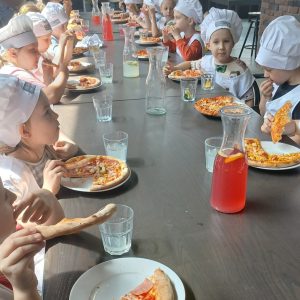 dzieci jedzące pizze.