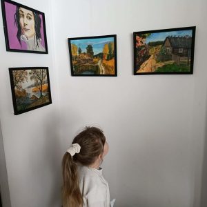 Dziewczynka z zaciekawieniem ogląda obraz