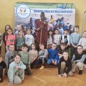 Grupowe zdjęcie uczniów klasy 1 z Masajem w tradycyjnym stroju.